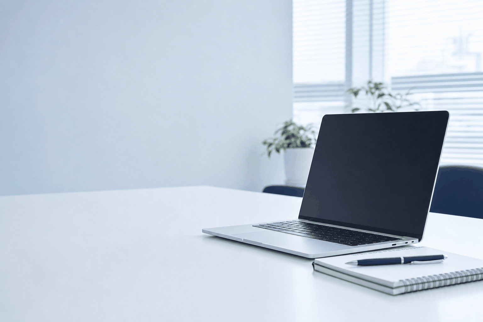 明るい事務所の机に置かれたノートPC